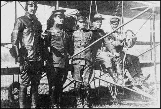 A group of men standing in front of an airplane.