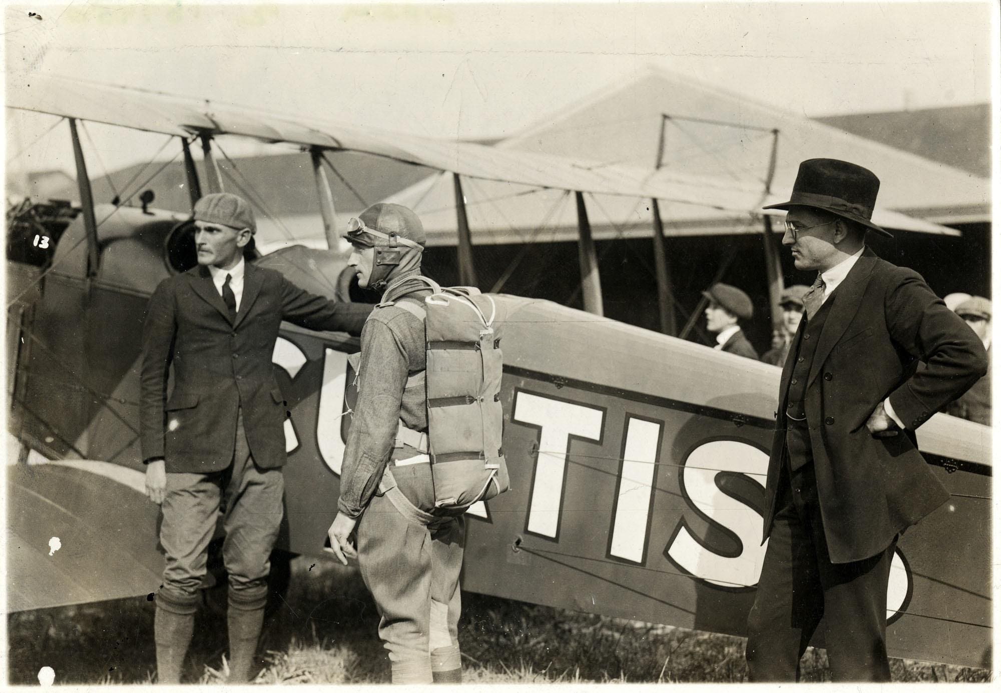 MSgt. Ralph Bottriell about to board an airplane with a parachute strapped to his back.