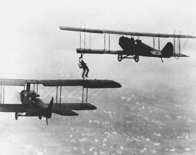 Wesley May hanging between two planes midair.