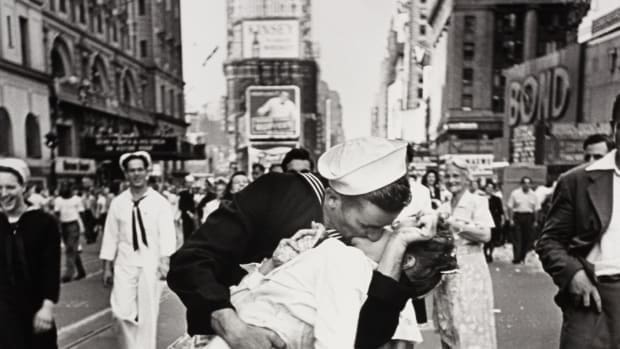 A man and woman kissing in the street on VJ Day.