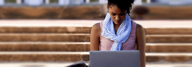 Students and Graduates Link Button Image - a students studying with a computer