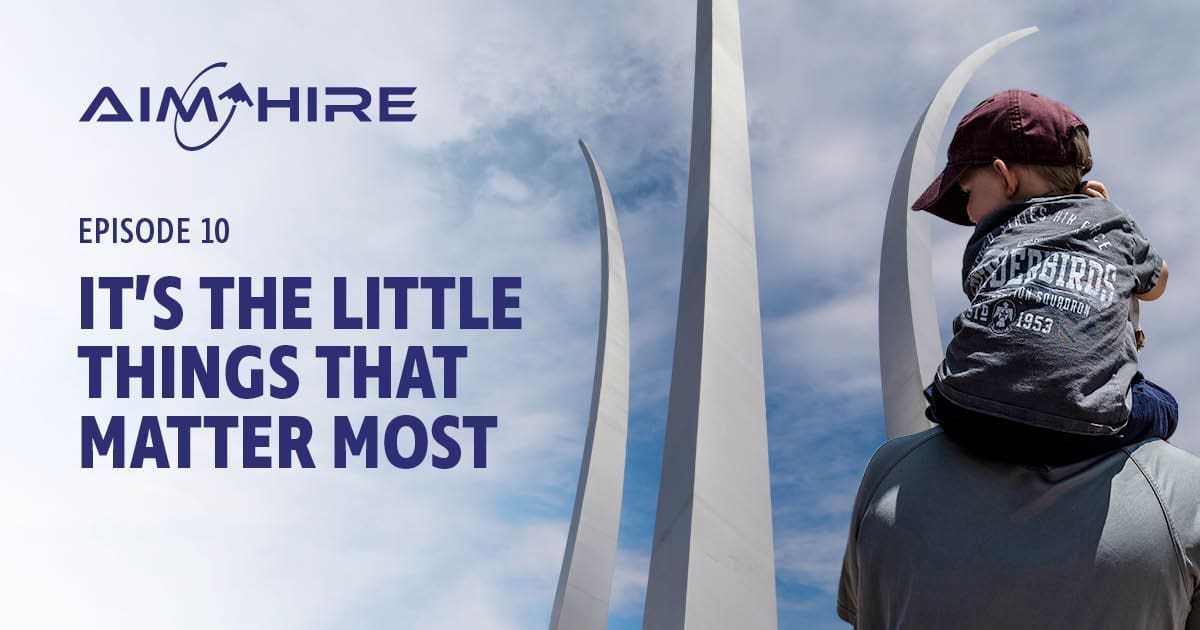 Aim Hire Episode 10: It's the Little Things that Matter Most. A Little boy sits on a man's shoulders, a three prong sculpture extends into the sky in the background.