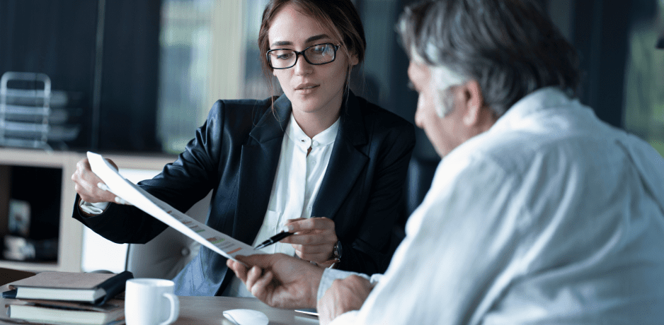 Two people looking at a document together.