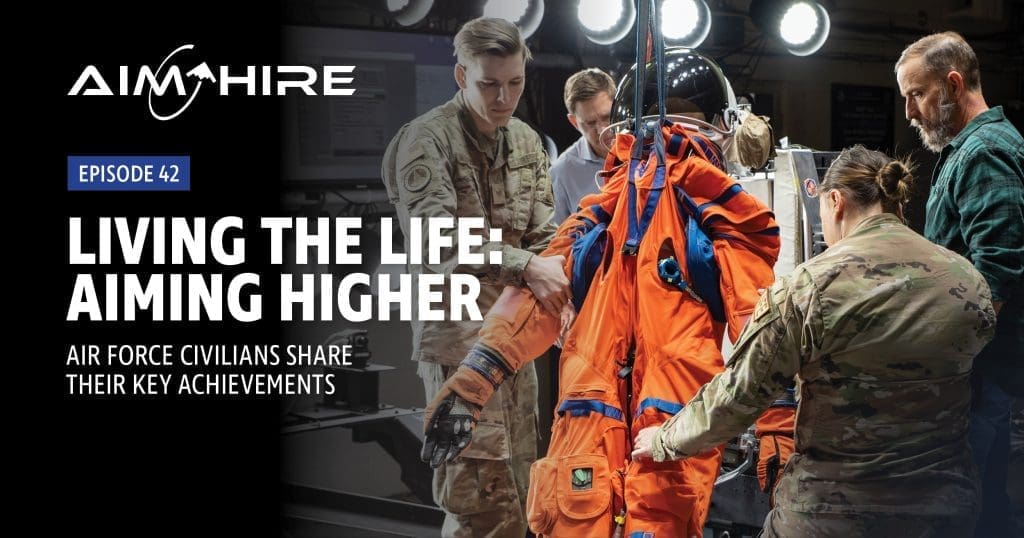 Aim Hire: Living the Life, Aiming HigherAim Hire Episode 42: Living the Life: Aiming Higher. A group of people tending to a space suit.