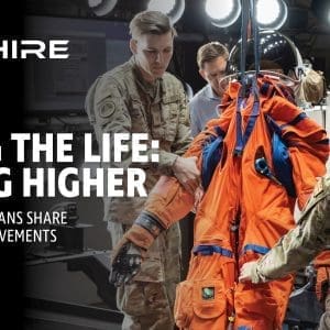 Aim Hire: Living the Life, Aiming HigherAim Hire Episode 42: Living the Life: Aiming Higher. A group of people tending to a space suit.